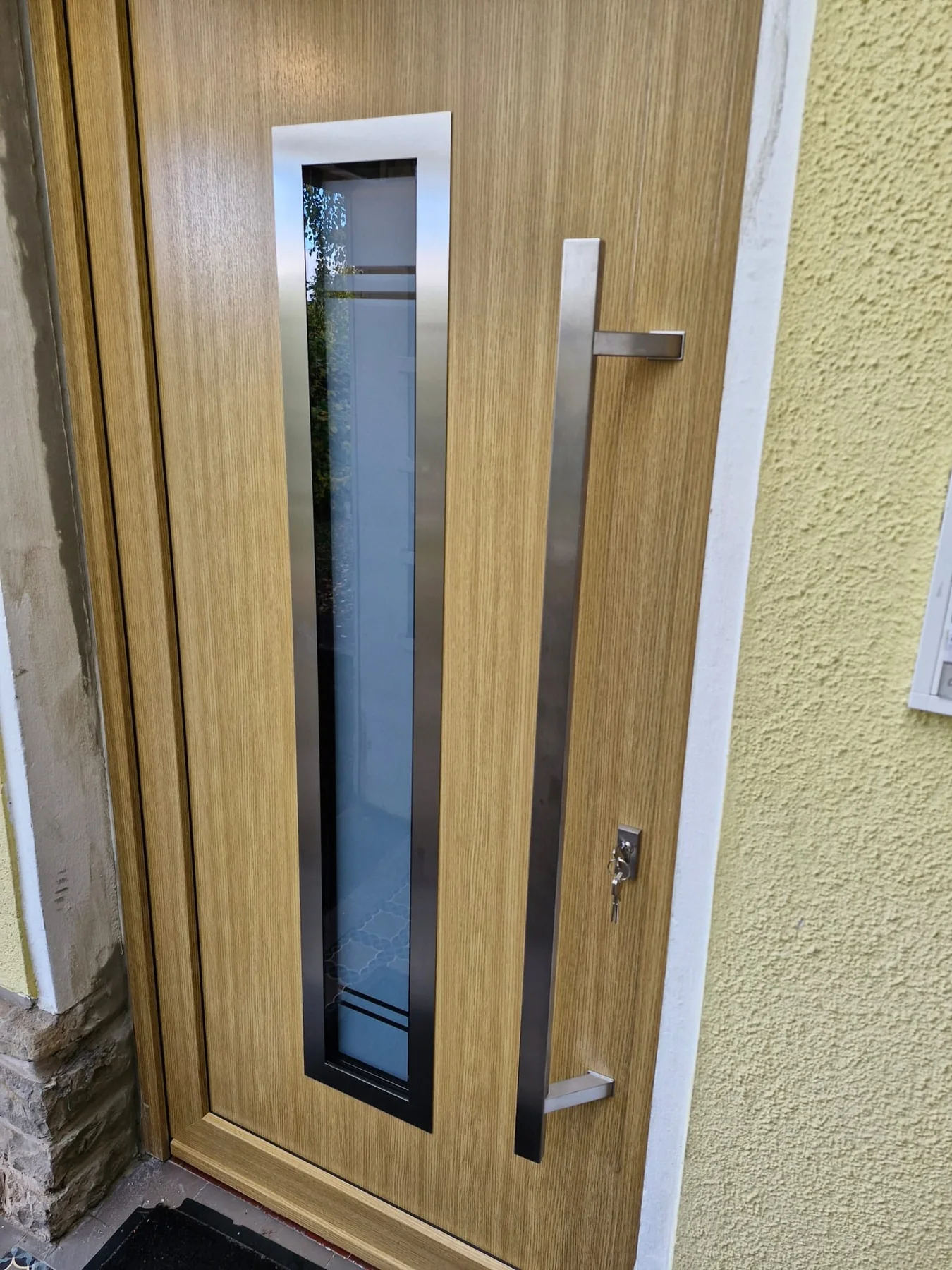 Neue Haustür in Holzoptik mit Glasausschnitt
